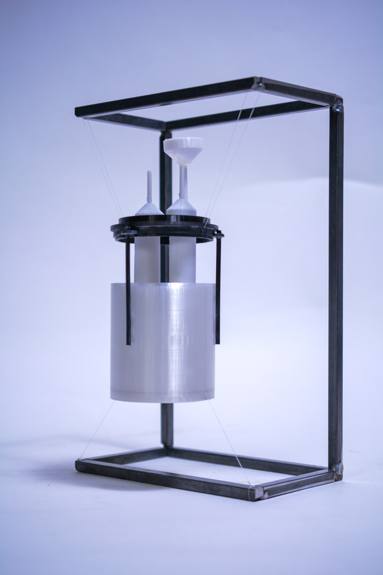 Fragment model — sealed process vessel suspended in a welded steel display frame
